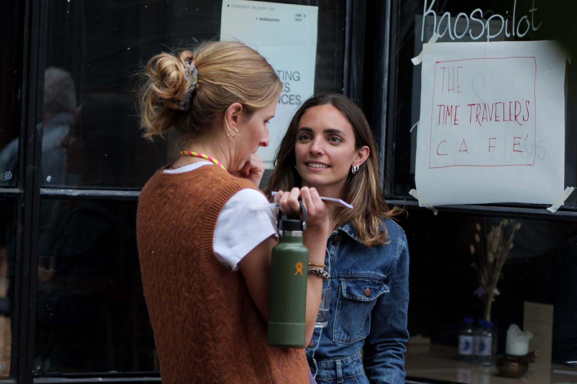 Two participants talking outside the Kaospilot building during the Lab Day