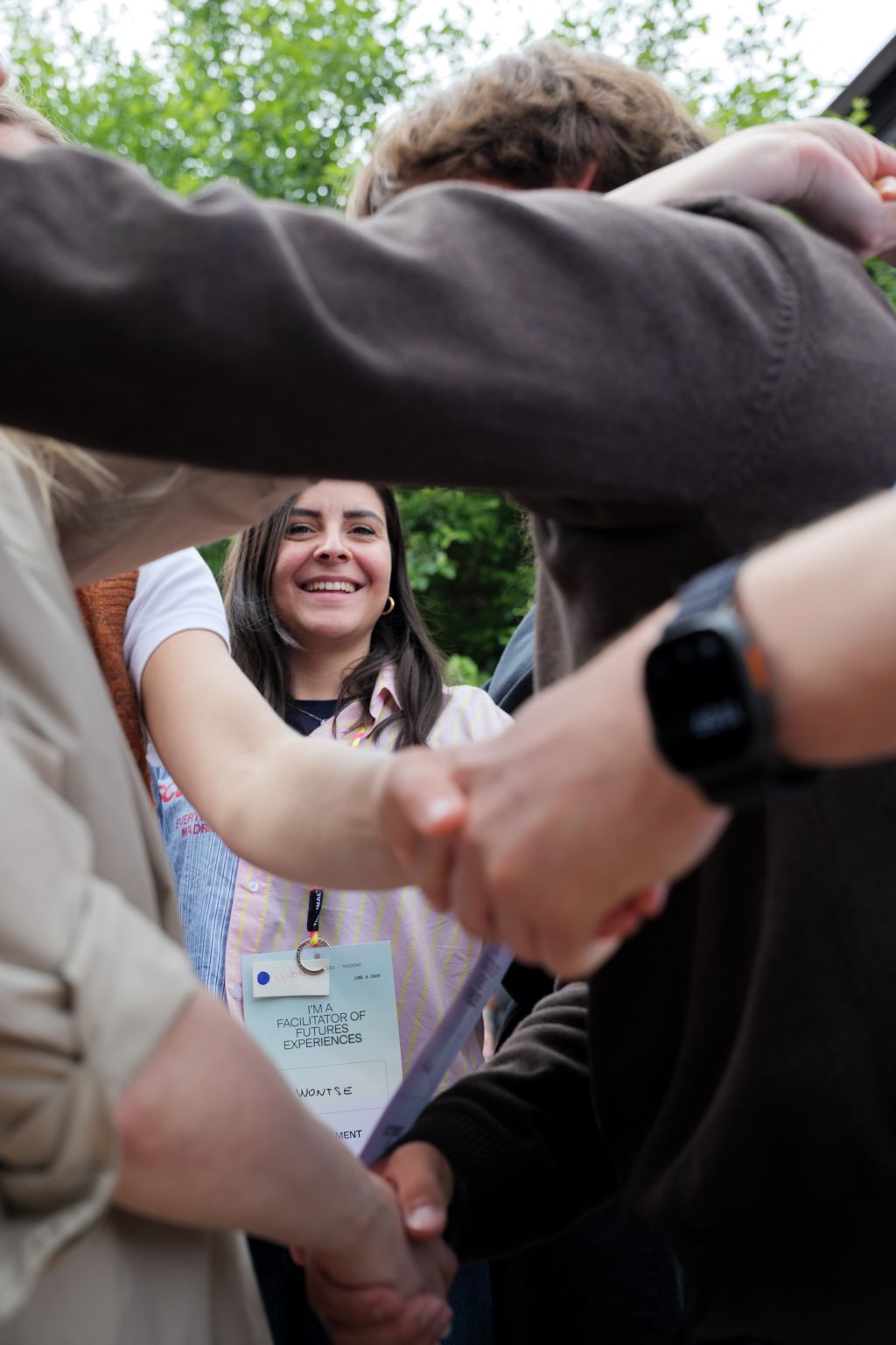Participants standing in a circle holding hands during a closing reflection