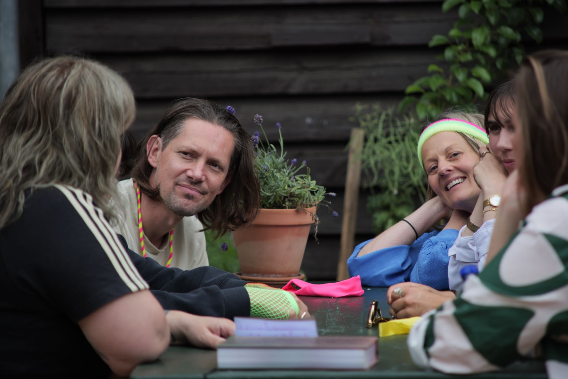 A group of participants sitting around a garden table in conversation